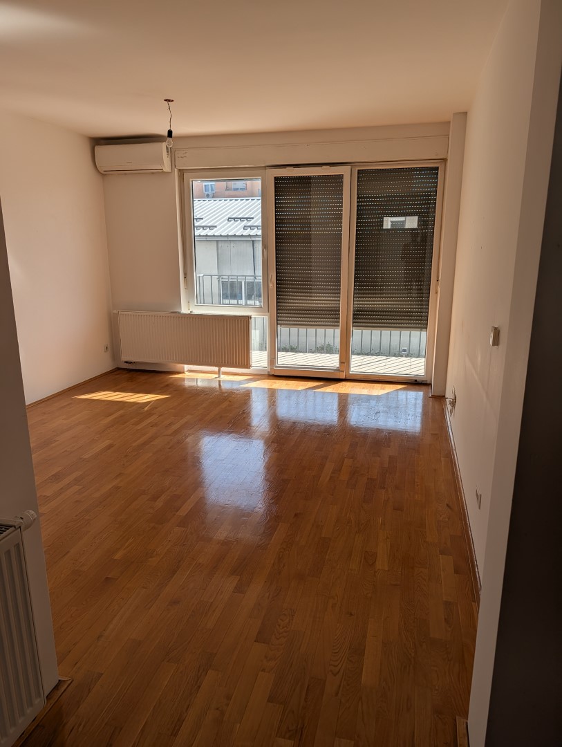 Dnevni boravak s klima uređajem i vratima na balkon
